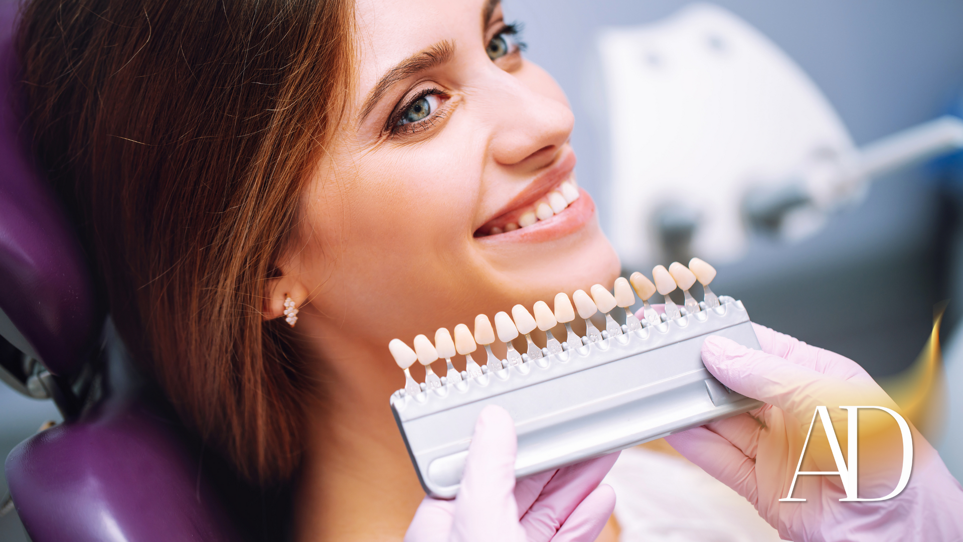 Woman smiling while holding a shade guide at a dental clinic