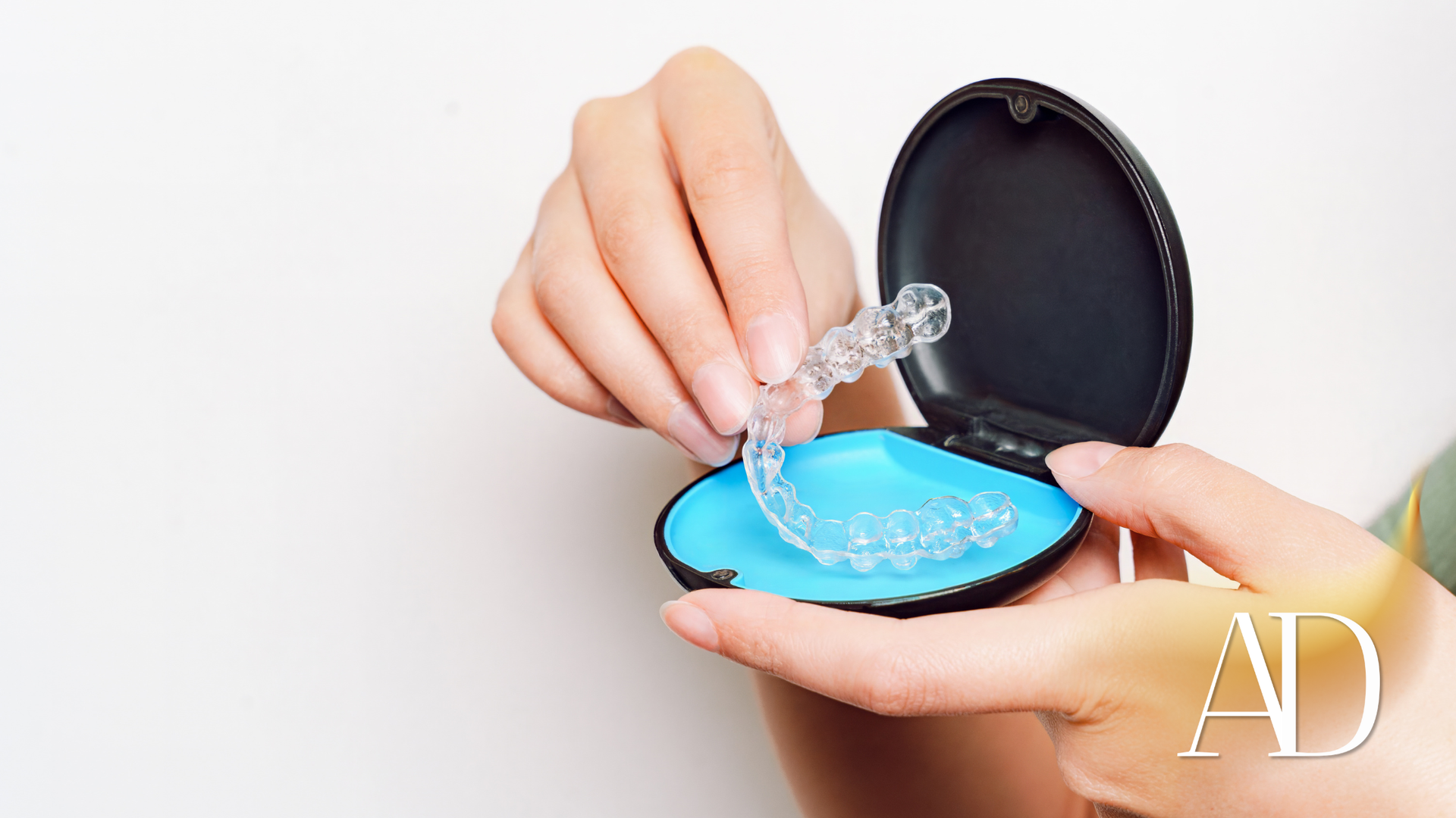 Hand holding a contact lens case, placing a clear lens into a blue solution cup