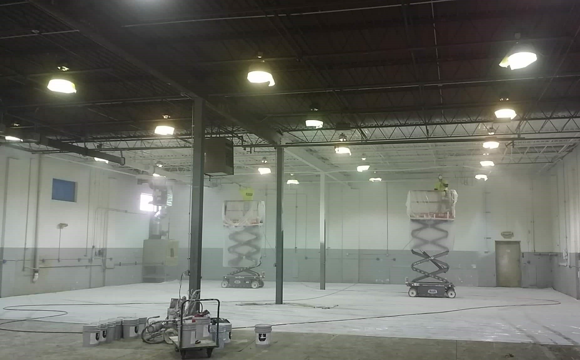 commercial painters painting warehouse on multiple lifts in York PA