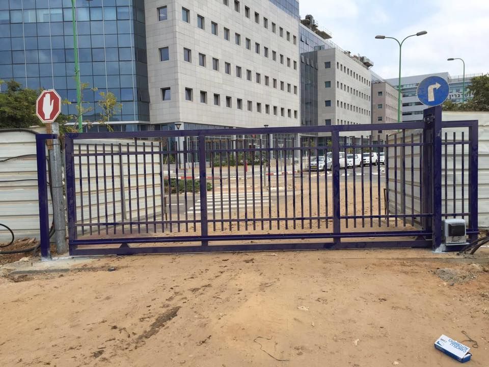 שער קונזולי מסיבי בצבע לבן המותקן בכניסה למתחם, דוגמה לאיכות ההתקנה של שערים חשמליים קלים וכבדים.