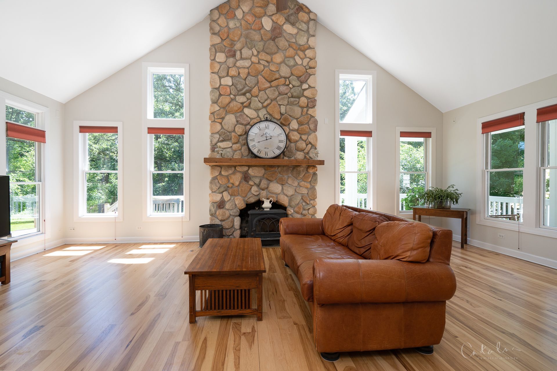 Interior photo of expansive family room with cathedral ceiling and stone fireplace sold by Cat Cusimano in Marengo, Illinois