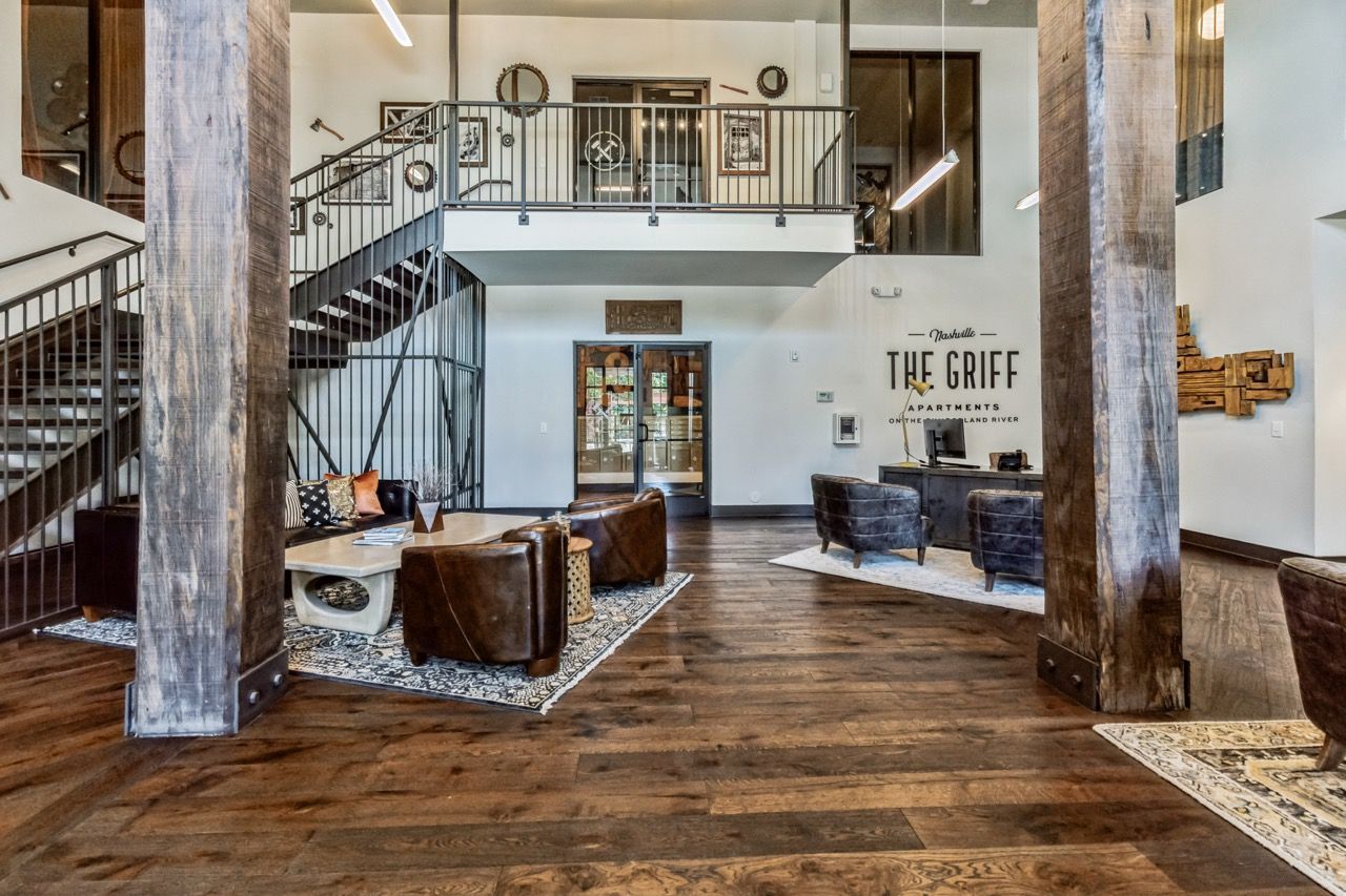Lobby with wood floors, leather seating, a staircase, and The Griff signage.