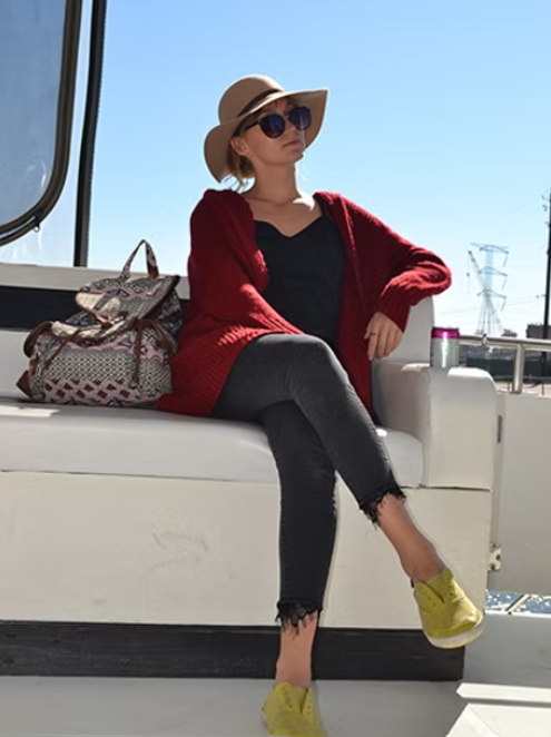 A woman wearing a hat and sunglasses is sitting on a boat