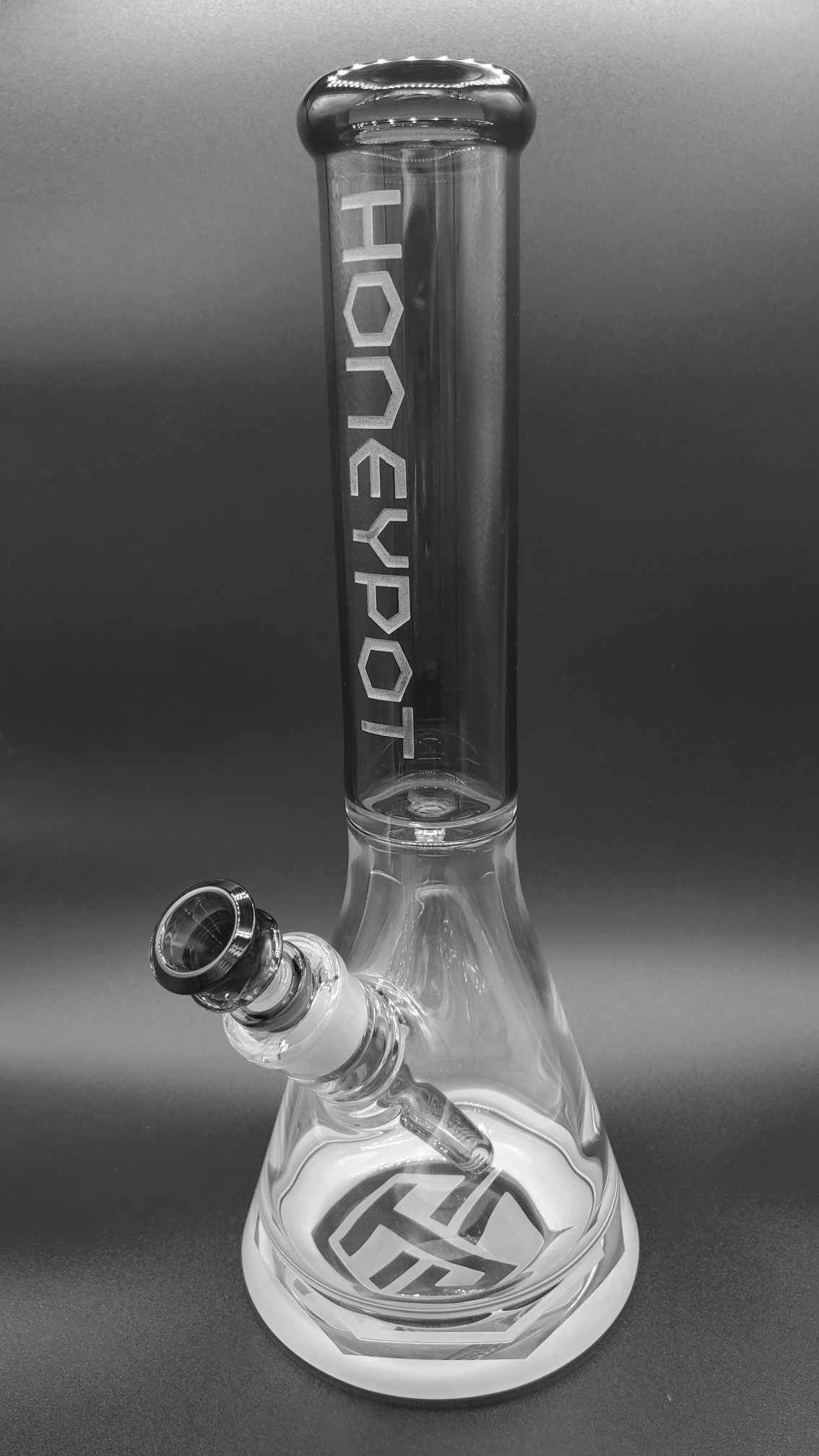 A clear glass beaker-style water pipe with the text 