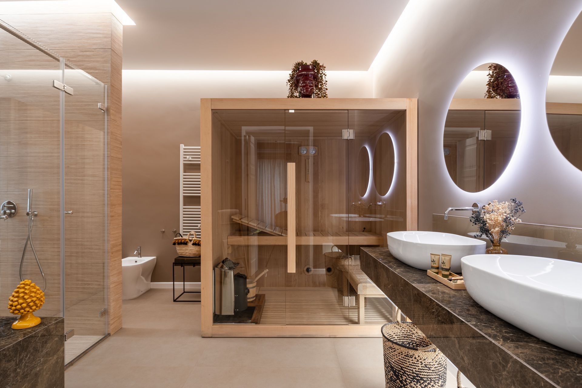 Luxurious bathroom with sauna, double sinks, and shower in neutral tones.