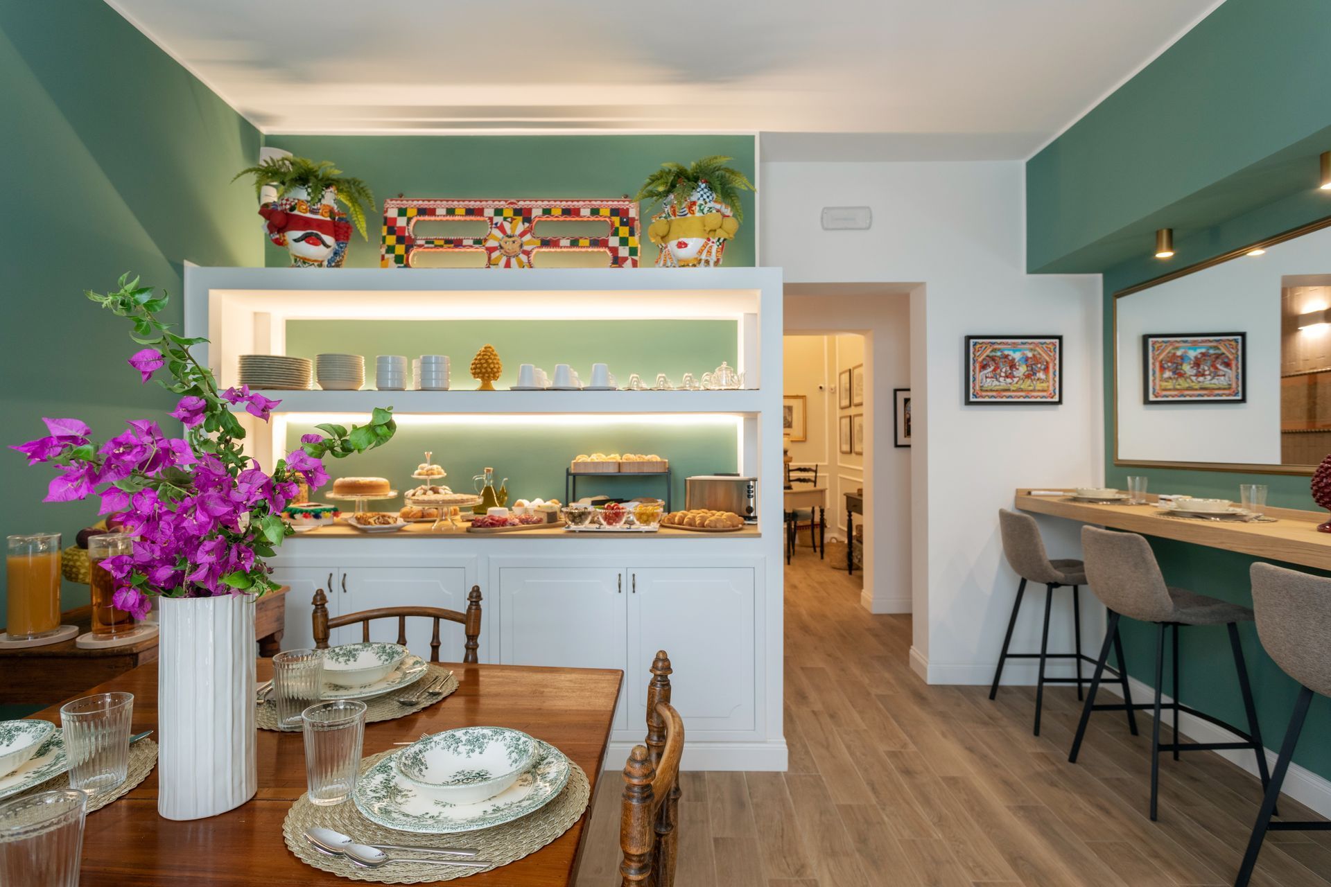 Petit-déjeuner buffet dans une salle à manger avec une longue table dressée pour les invités et un bar.