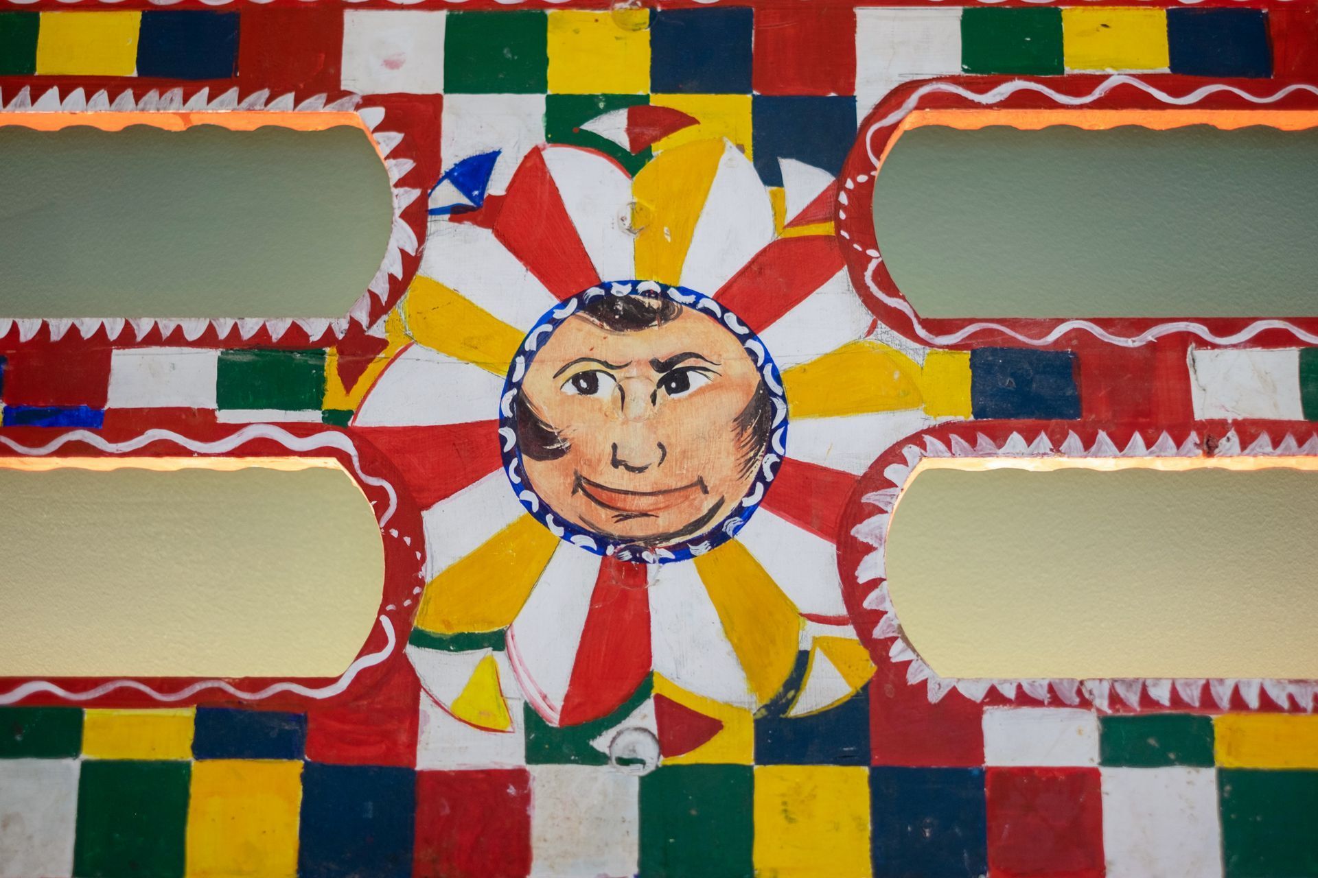 Parete colorata da carnevale con un sole sorridente e vetrine.