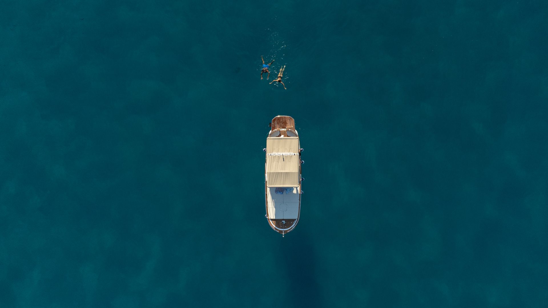 Bateau avec deux personnes nageant dans l'océan bleu clair.