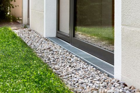 Gravel border beside a sliding glass door next to a green lawn.