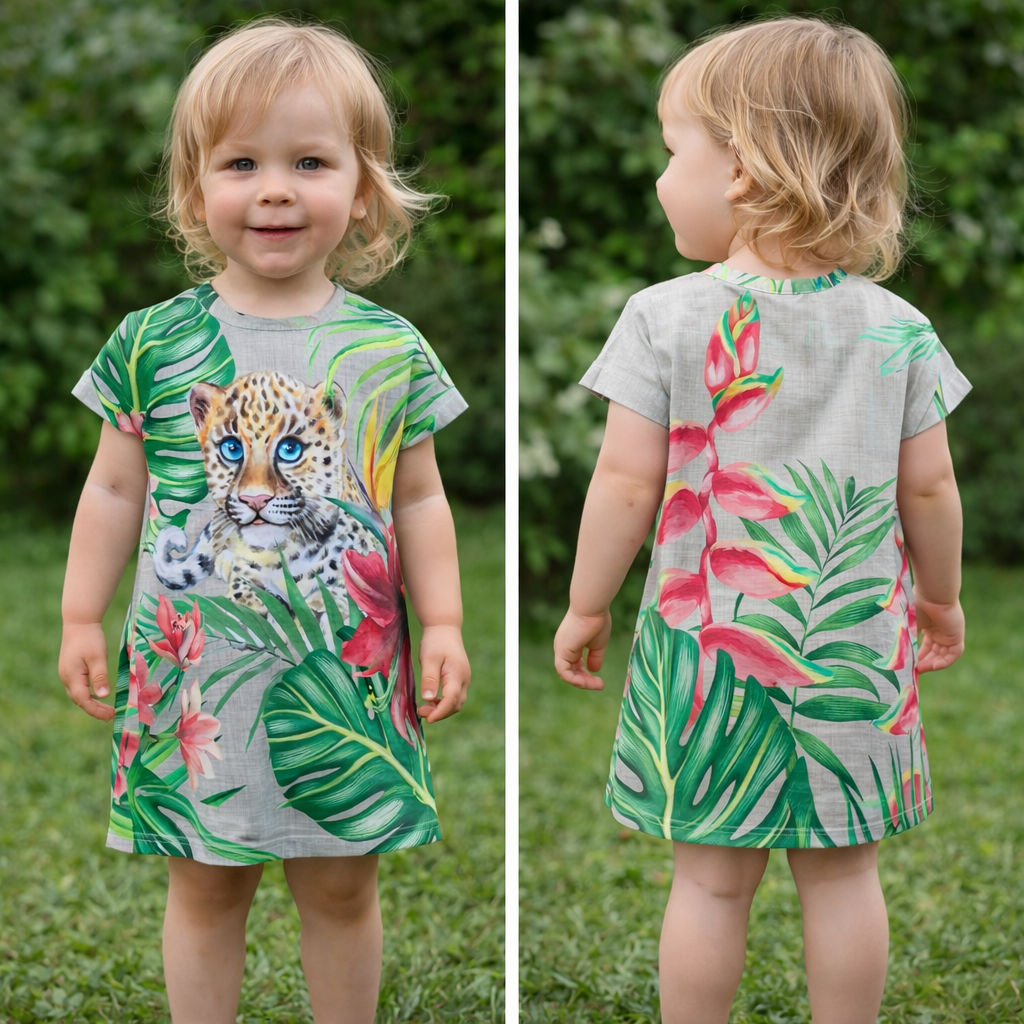 Peuter in groene jurk met jungleprint, van voren en van achteren gefotografeerd op het gras.