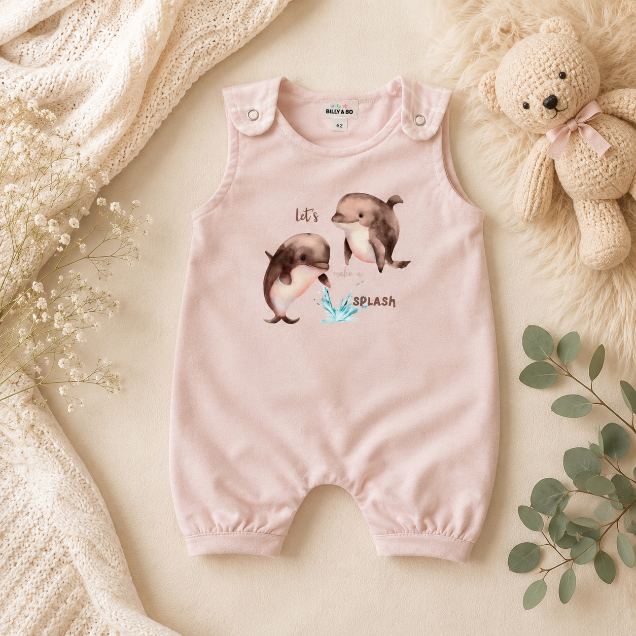 Een slapende baby in een roze outfit ligt op een zachte witte deken.