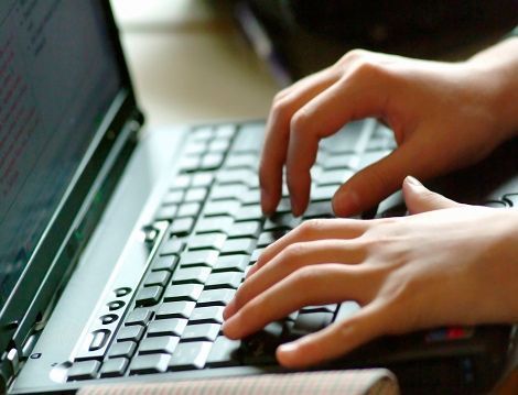 A person is typing on a laptop keyboard