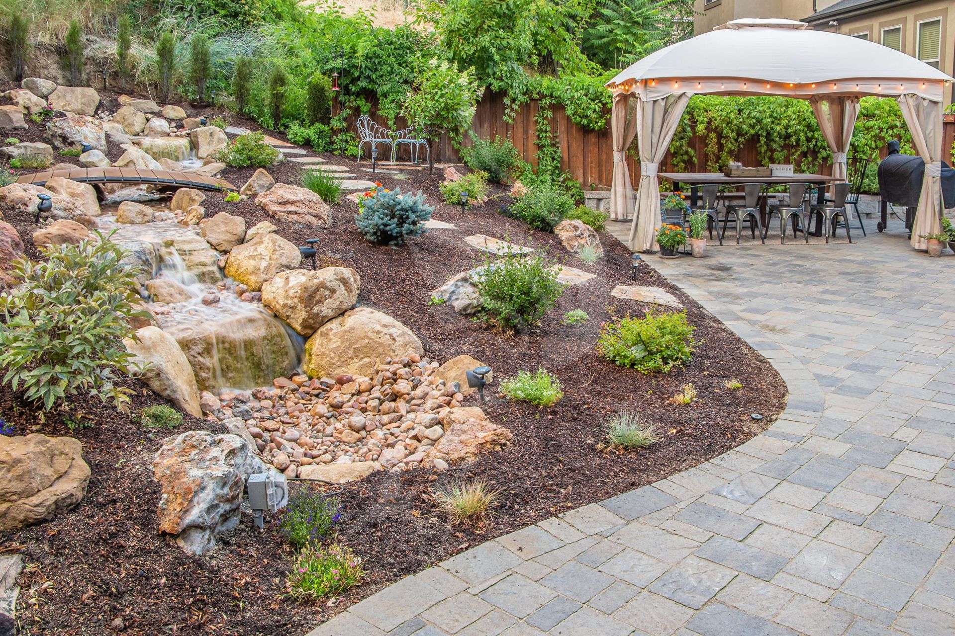 Landscaped backyard with stone patio.