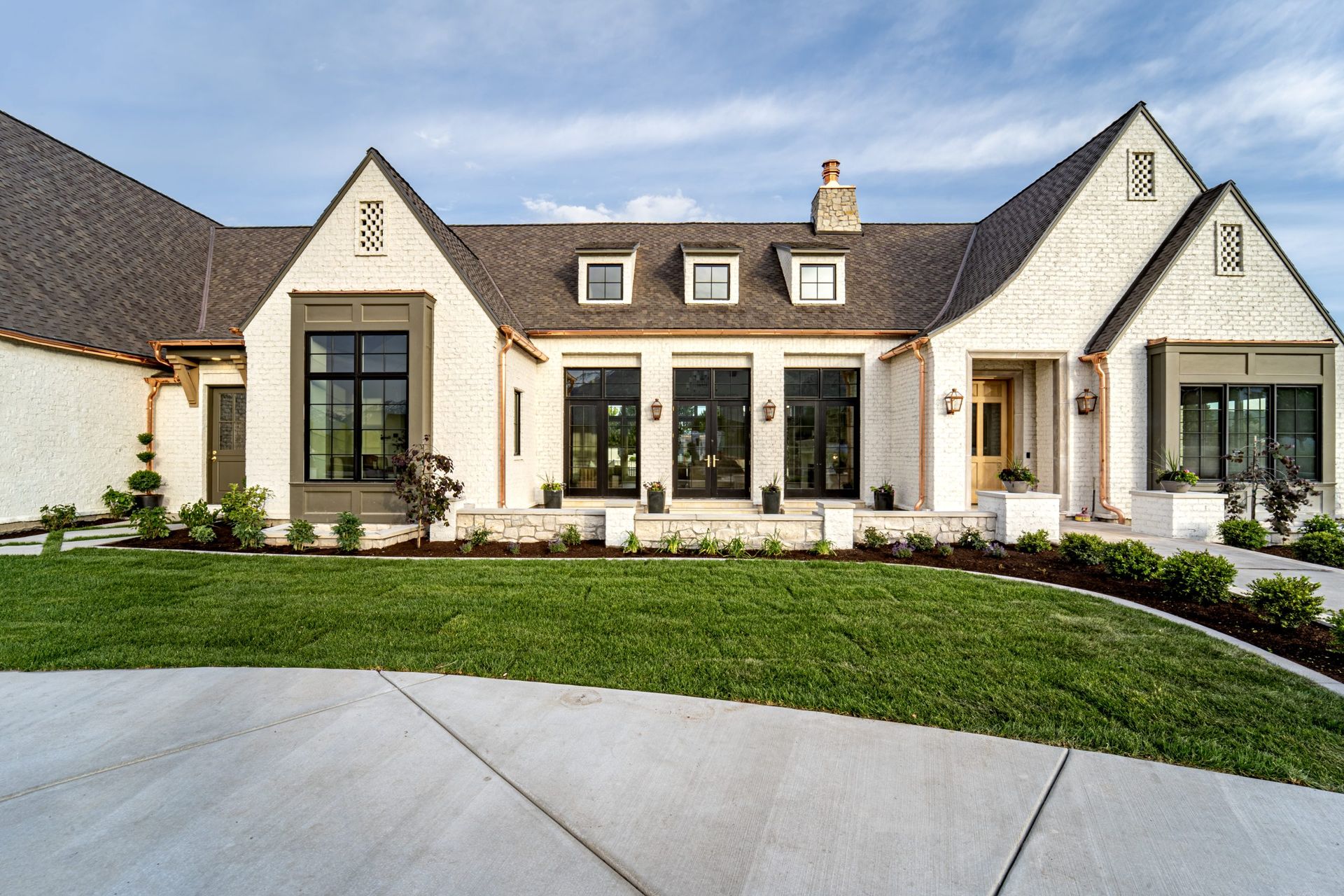 White brick house with green lawn.