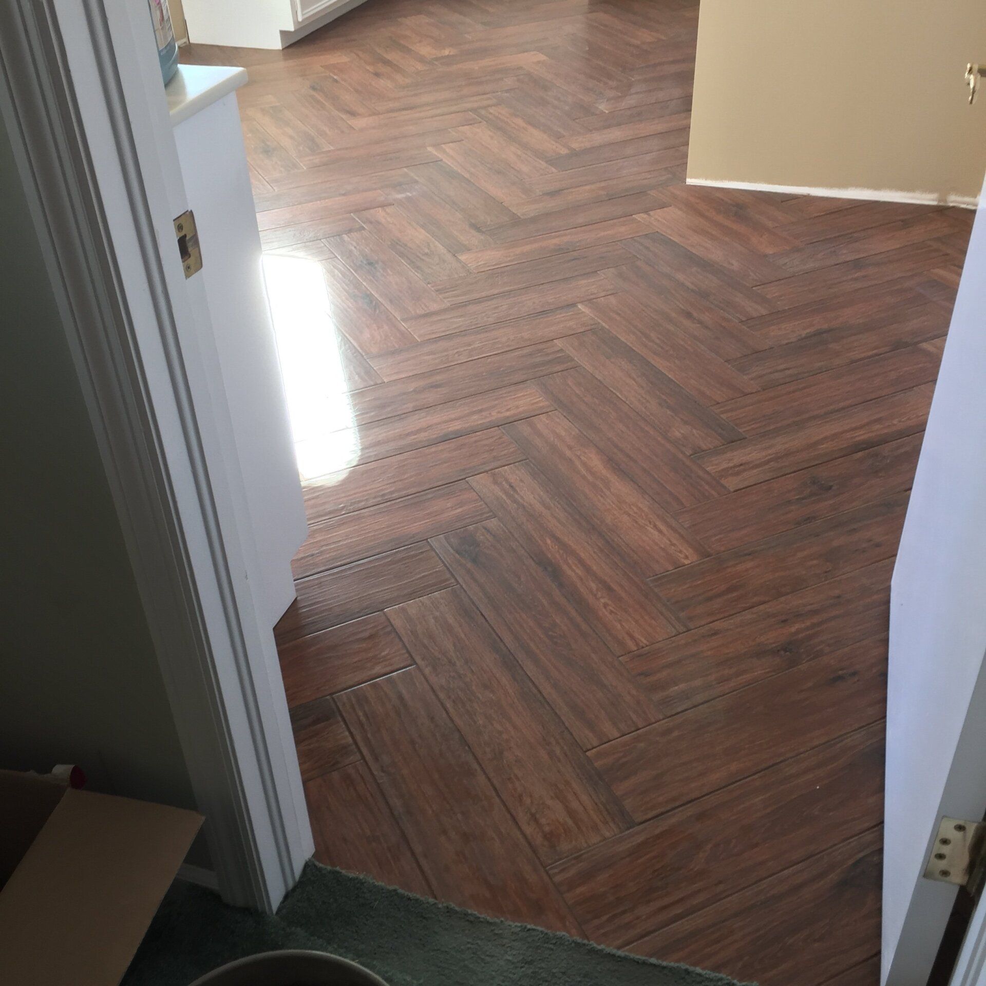 Dark brown herringbone wood floor viewed from doorway.