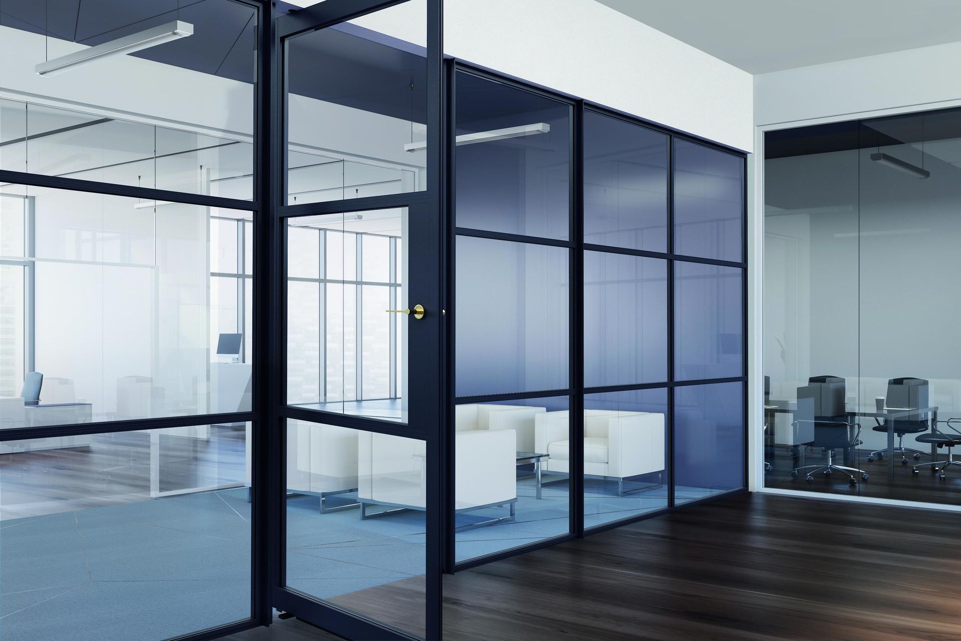 Modern office interior featuring glass wall partitions with black frames and blue-tinted glass, creating meeting rooms.