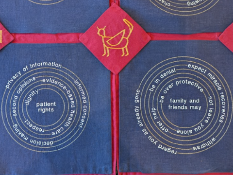 Blue tapestry with embroidered prompts around the topic of dying - by Chetan Shastri.