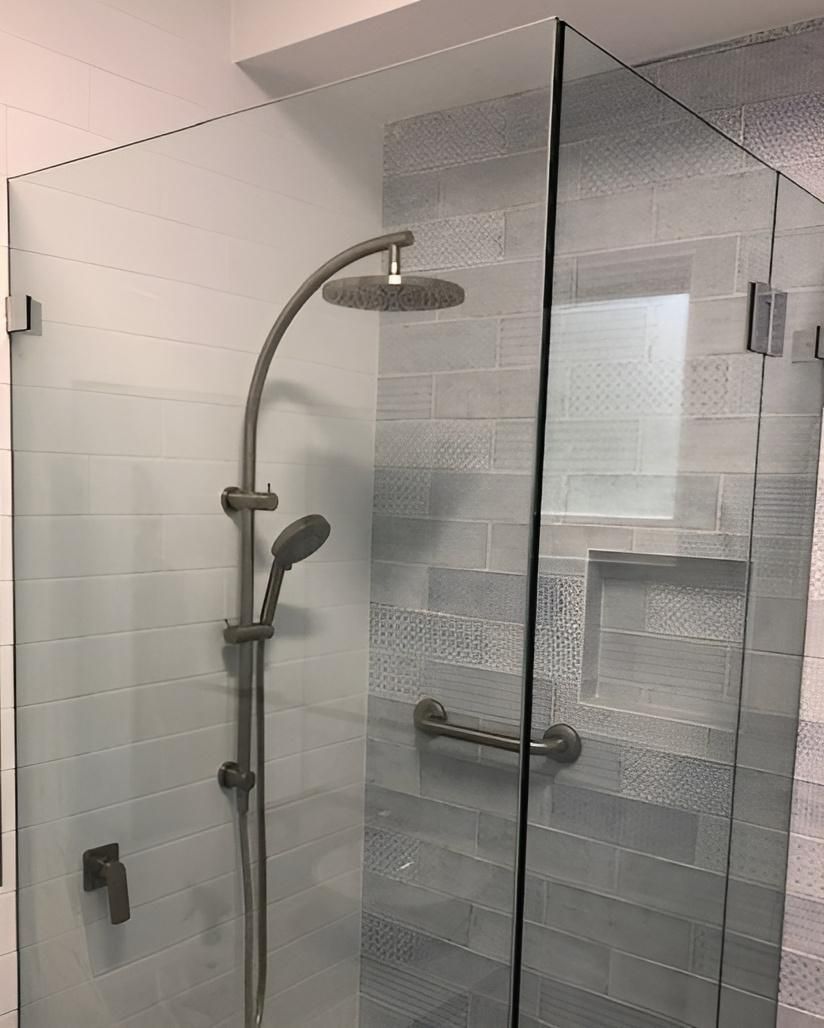 A Shower Stall with A Glass Door and A Shower Head — Bowral Bathrooms in Exeter, NSW