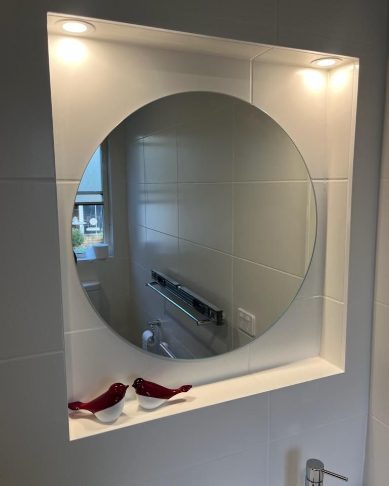 A Bathroom with A Round Mirror and Two Red Birds on A Shelf — Bowral Bathrooms in Berrima, NSW