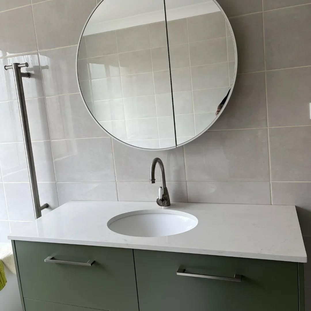 A Bathroom Sink with A Round Mirror Above It — Bowral Bathrooms in Bundanoon, NSW