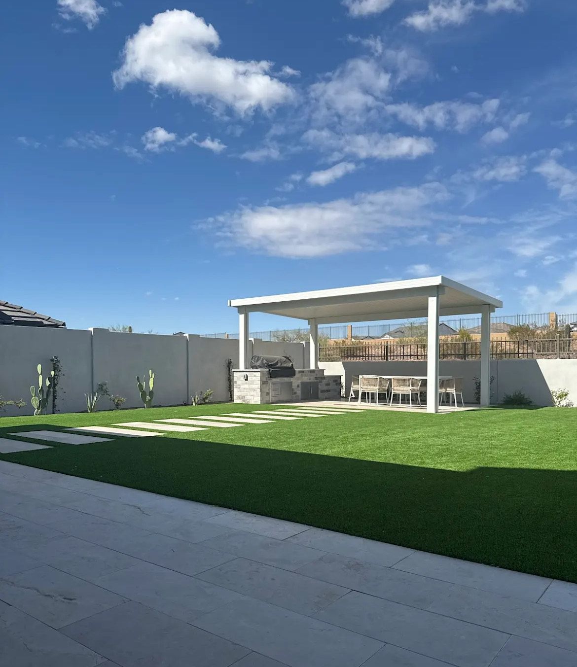 A backyard with a pergola and a table and chairs