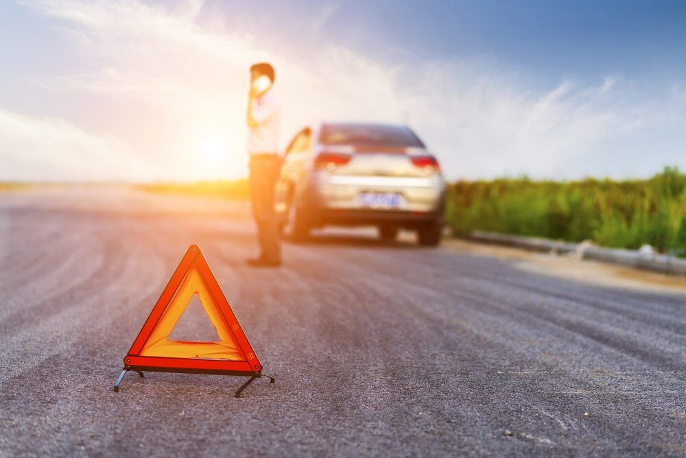 Man is Standing Next to a Broken Down Car on the Side of the Road — 365 Towing Taree in Taree, NSW