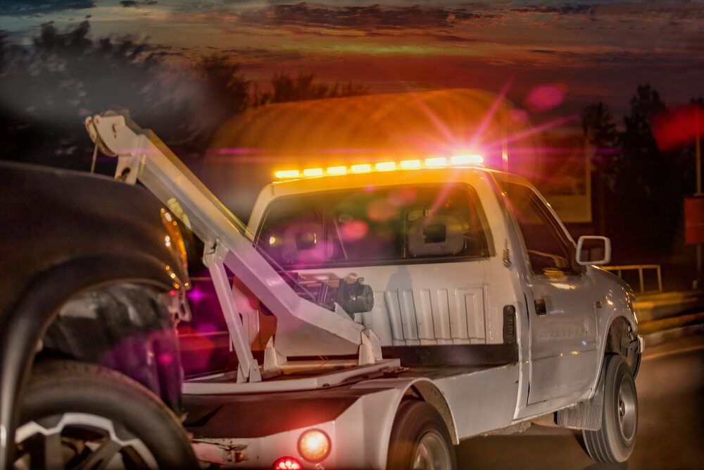 Tow Truck is Towing a Car on the Side of the Road at Night — 365 Towing Taree in Taree, NSW