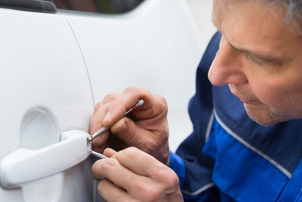 Man is Fixing a Car Door With a Screwdriver — 365 Towing Taree in Wingham, NSW