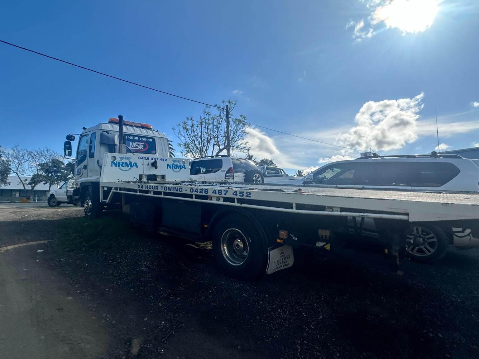 Tow Truck is Parked in a Parking Lot Next to a Car — 365 Towing Taree in Wingham, NSW