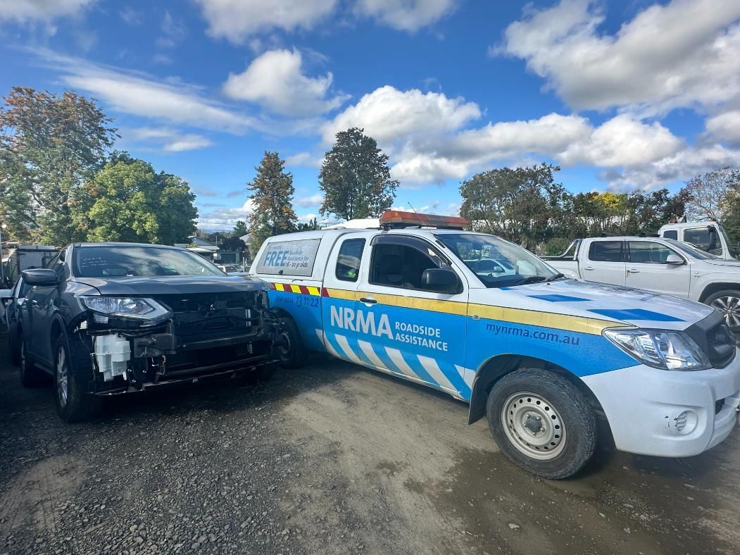 Blue and White Tow Truck is Parked Next to a Black Car — 365 Towing Taree in Wingham, NSW