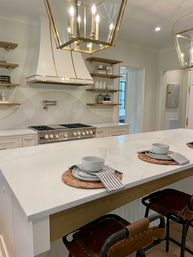 A kitchen with a large island and a stove top oven