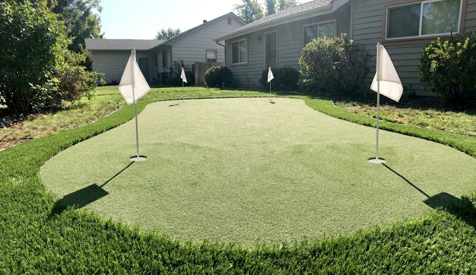 Custom backyard artificial turf putting green with two holes and realistic fringe grass.