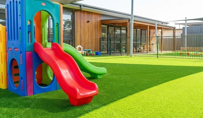 Safe artificial turf playground installation for a daycare in Raleigh NC with shock pad protection.