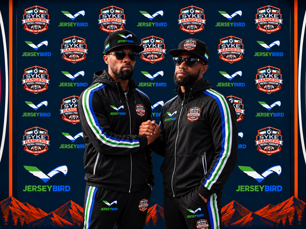 Three DMV Marksmen soccer players pose on a field