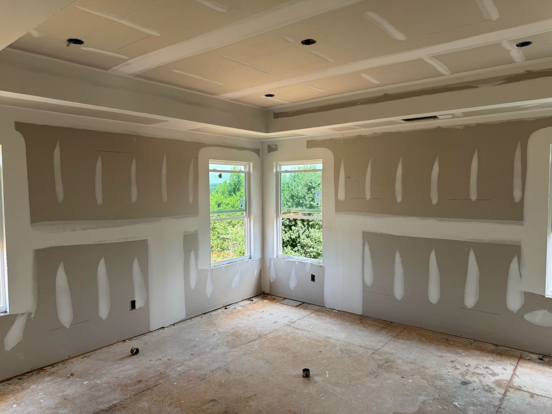 A room with a lot of windows and drywall on the walls