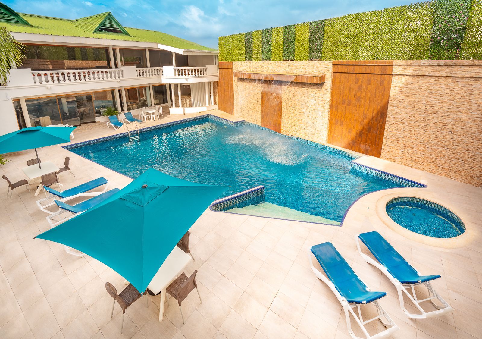 Hotel with pool in San Andrés, featuring lounge areas, umbrellas, and guest spaces.