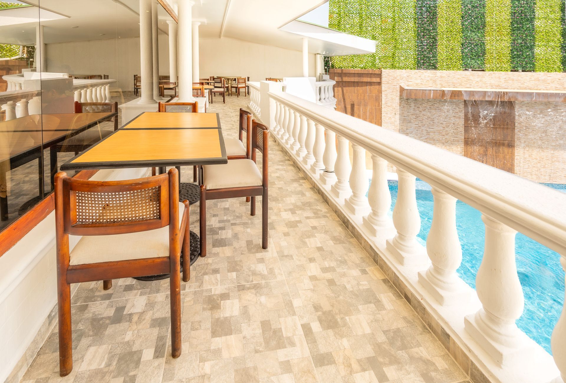 Terraza con mesas junto a la piscina en Hotel Américas SAI, hotel restaurante en San Andrés para desayunos sin afán.