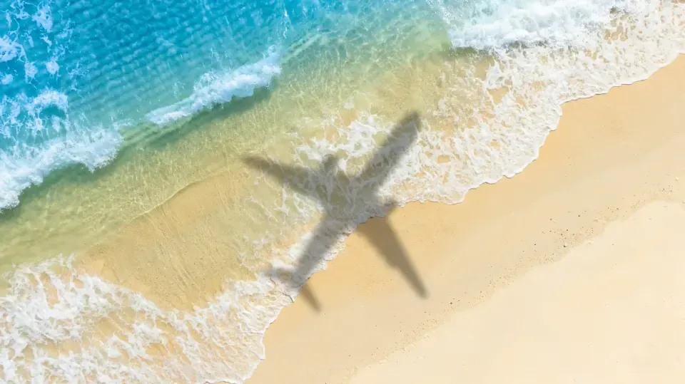 Sombra de avión en la arena y el mar en viajes a San Andrés.