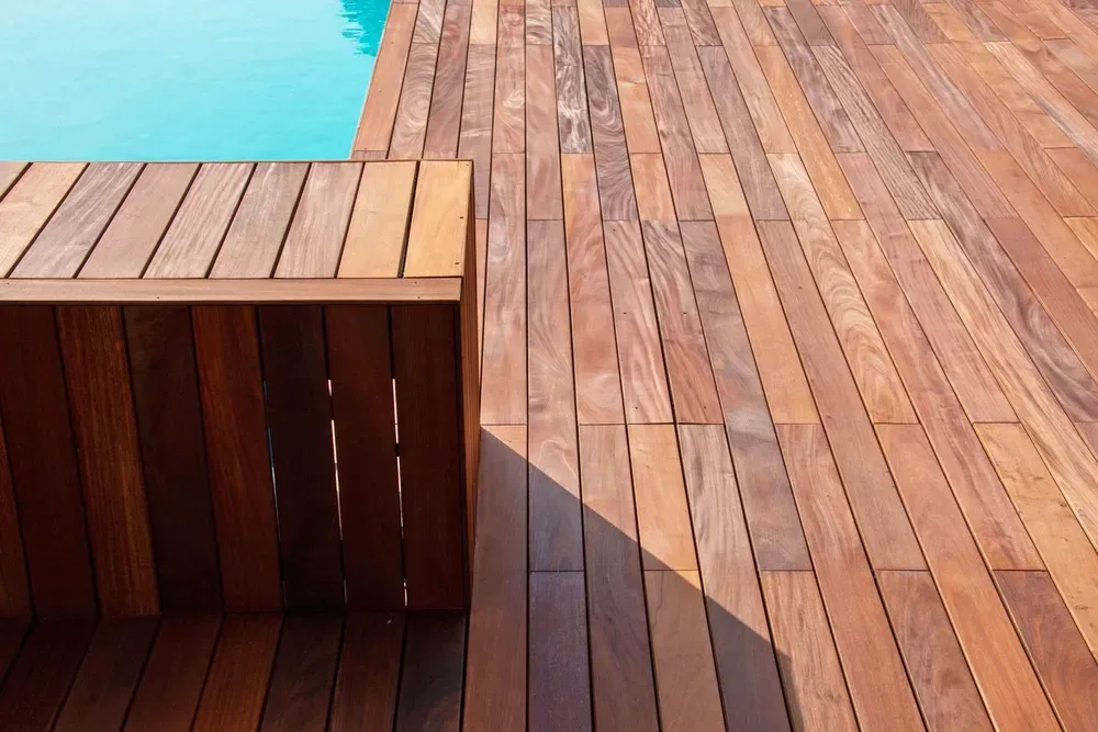 A Wooden Deck And Bench Poolside — CAW Services in Badagarang, NSW