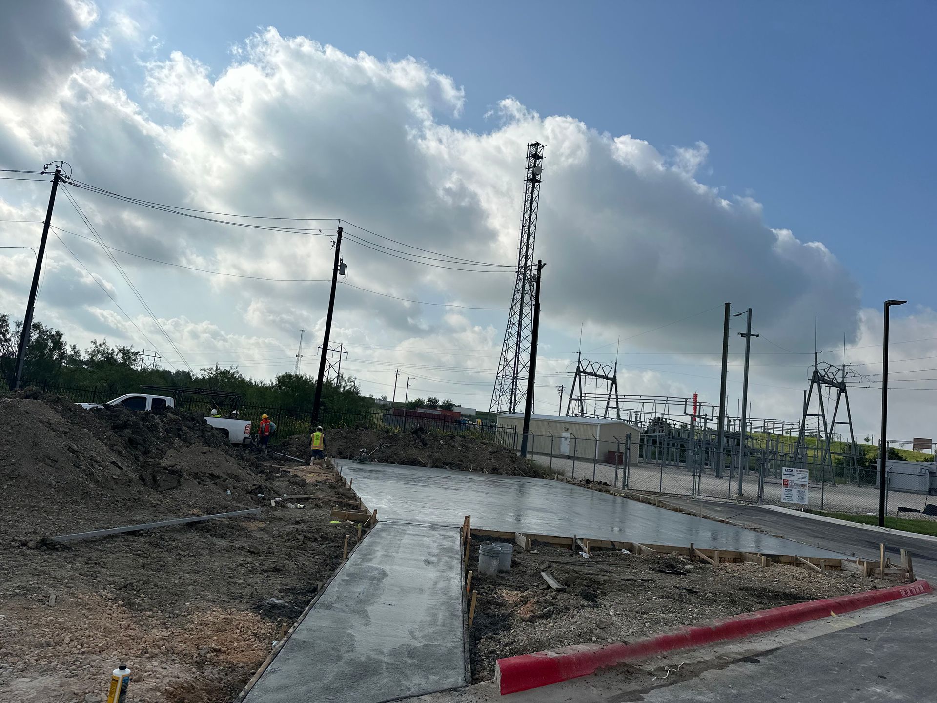 A concrete walkway is being built on the side of a road.