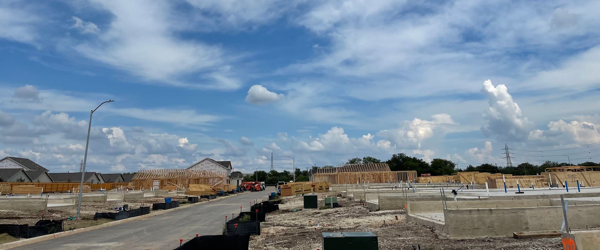 A construction site with a blue sky and clouds in the background.