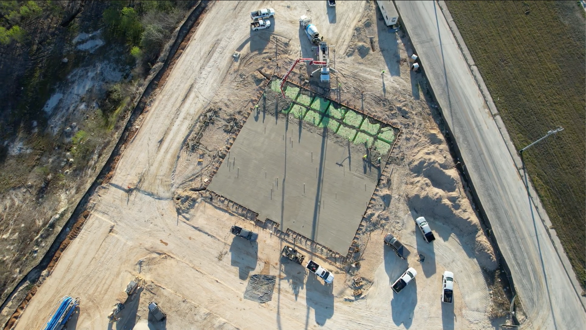 A concrete pump is pouring concrete on a construction site.