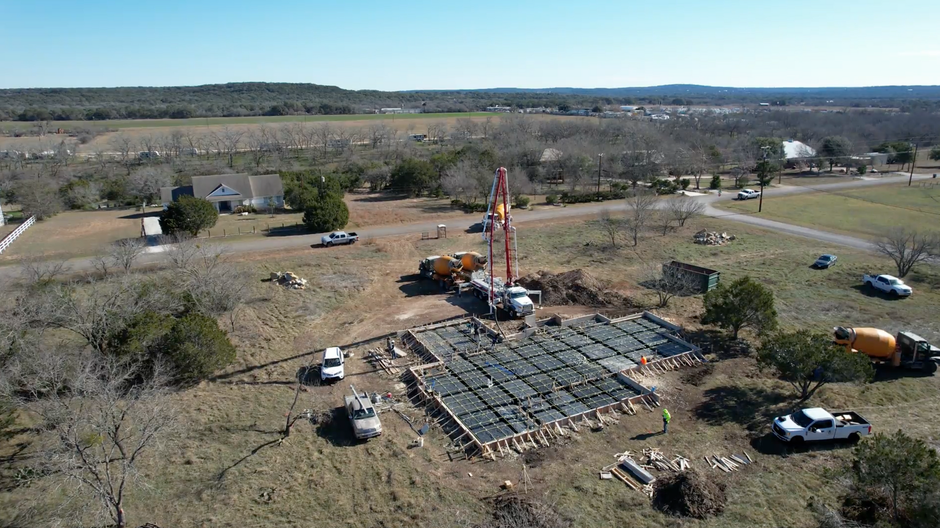 An aerial view of a construction site with trucks and a crane.