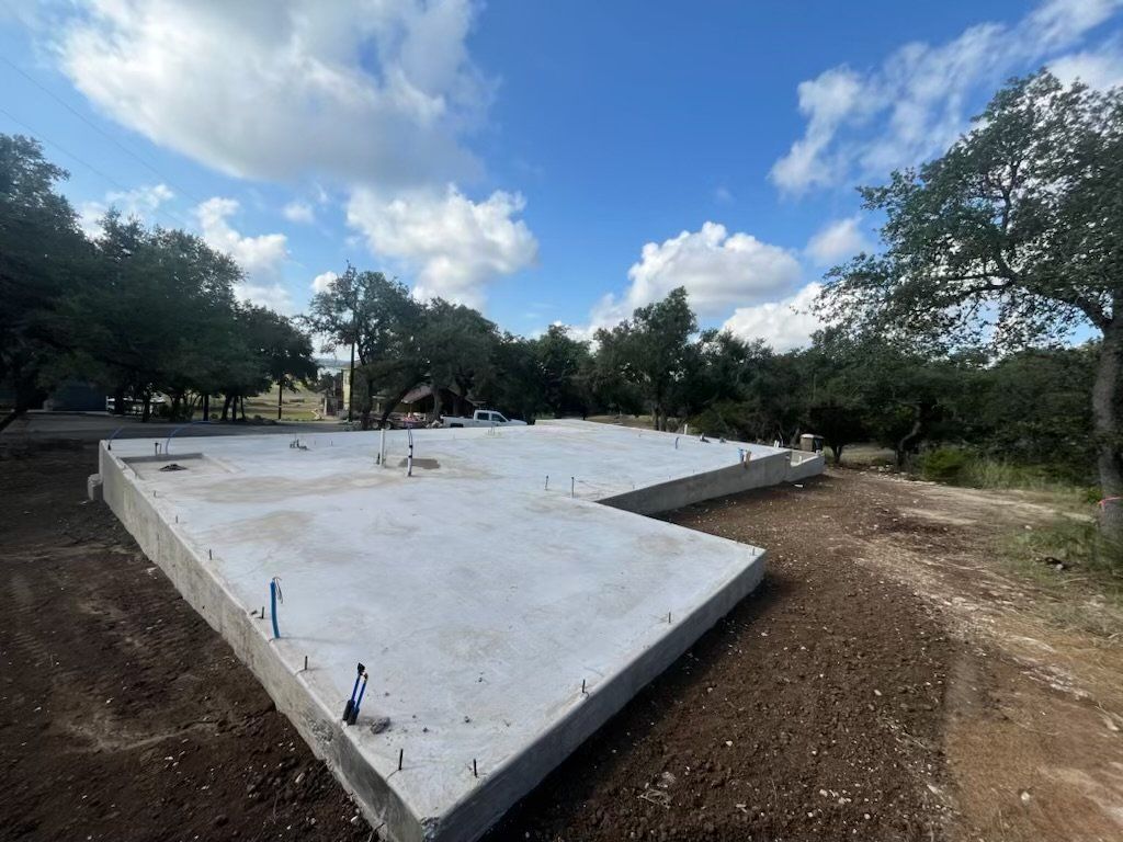 A large concrete slab is sitting in the middle of a dirt field.