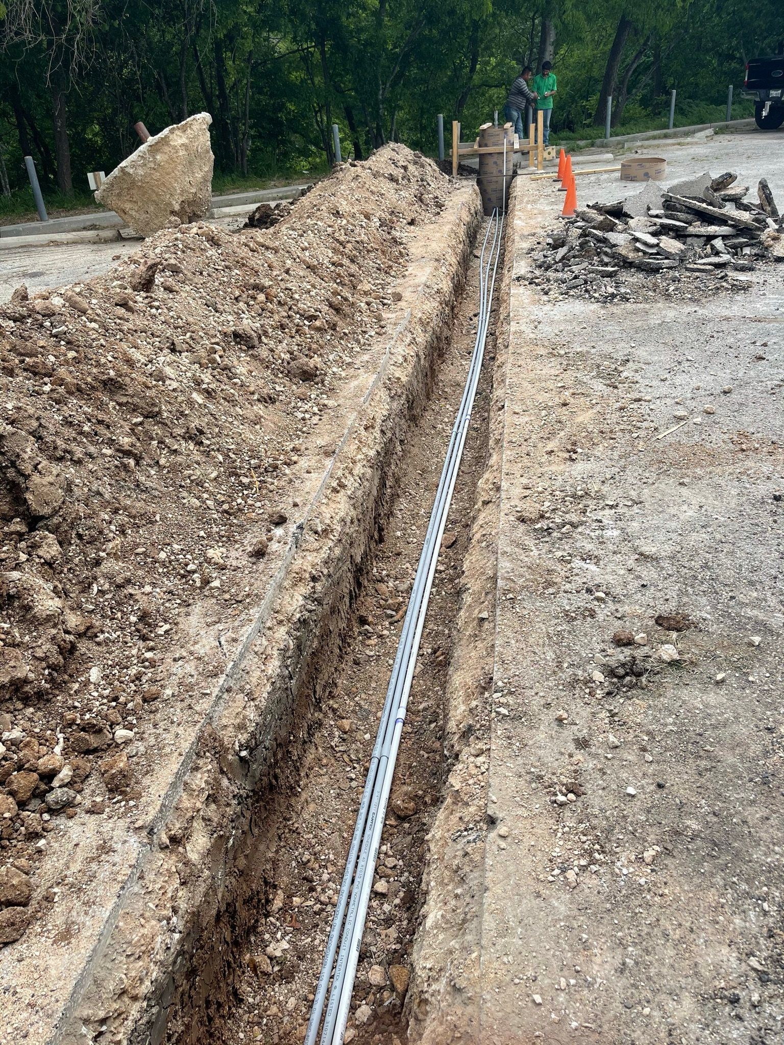 A pipe is being installed in a trench in the dirt.