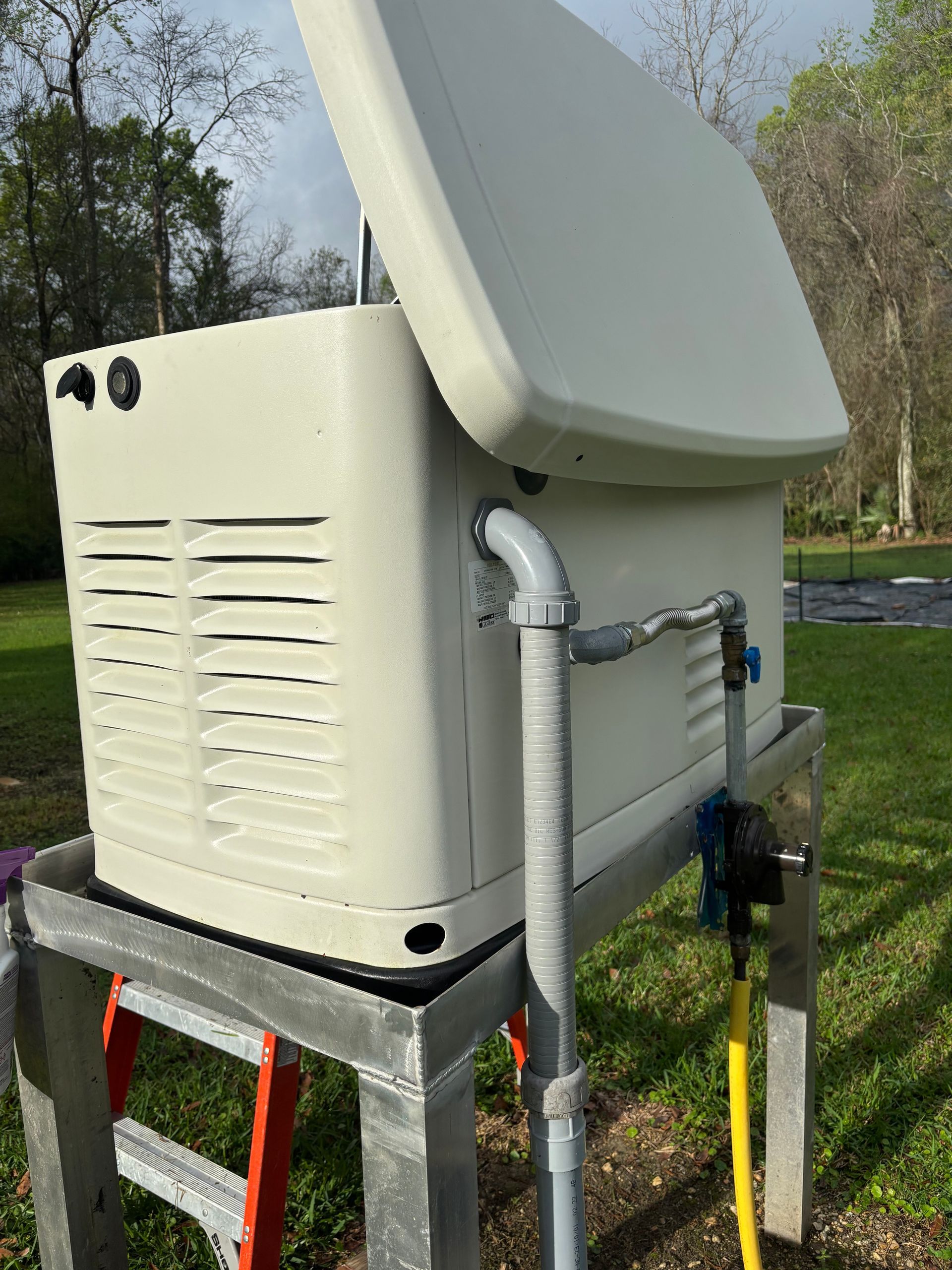 Beige industrial machine with open lid and hoses mounted on a metal frame outdoors.