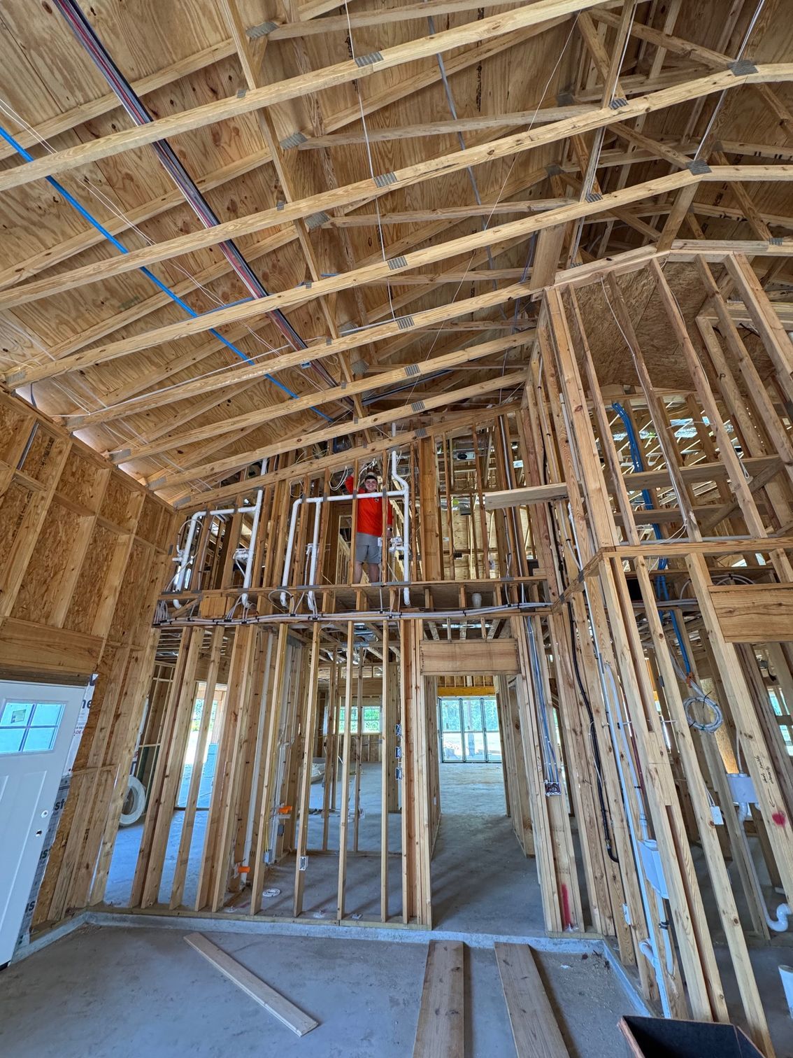 Framed interior of a house under construction with exposed wooden rafters and wall studs
