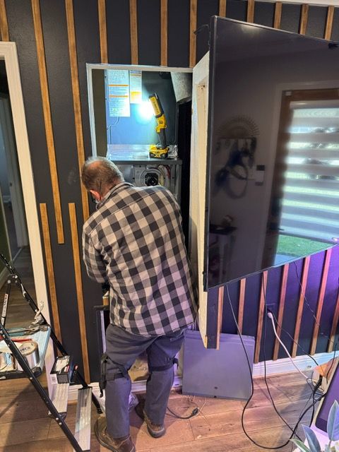 Person working on a large display in a studio with black and gold striped walls.
