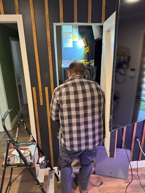 Person standing in a workshop doorway, facing a lit room with tools and a bicycle nearby.