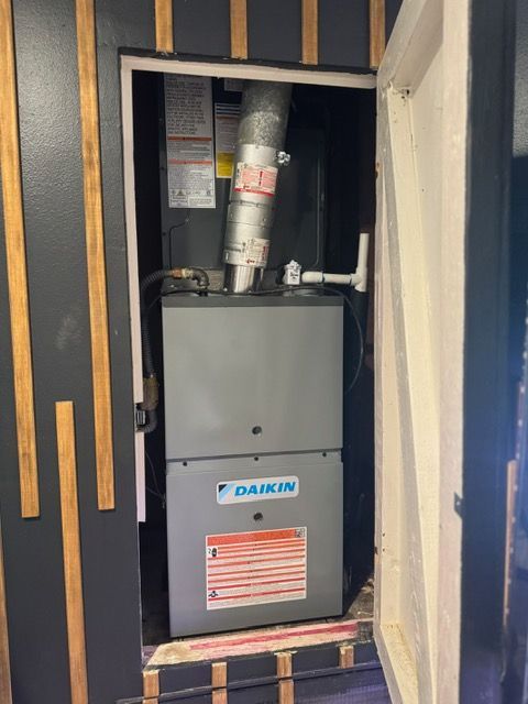 Daikin furnace installed in a narrow closet with exposed ducts and surrounding wooden framing